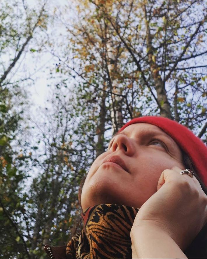 Johanna Jämsä katsoo taivaalle, taustalla puita